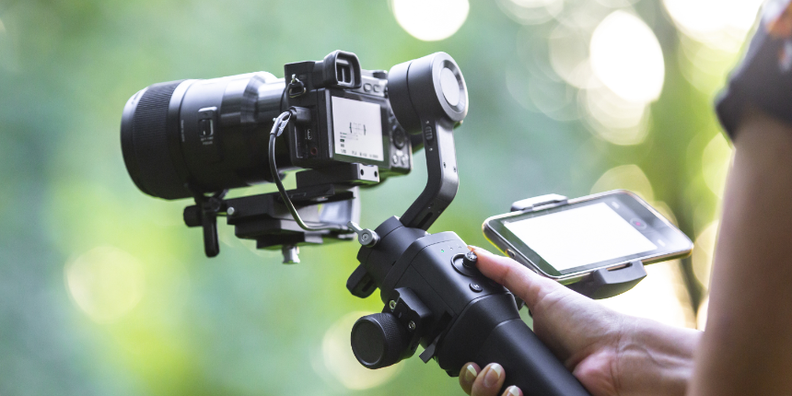 Bild von einem Gimbal mit Kamera bei der Bedienung - Sinnbildlich für die offene Stelle als Digital Marketer / Content Creator